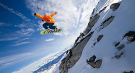 Snowboarder jumping above rocks, Switzerland
